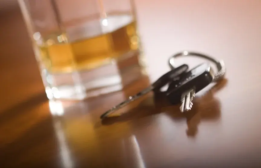 Car keys and drink in glass on table