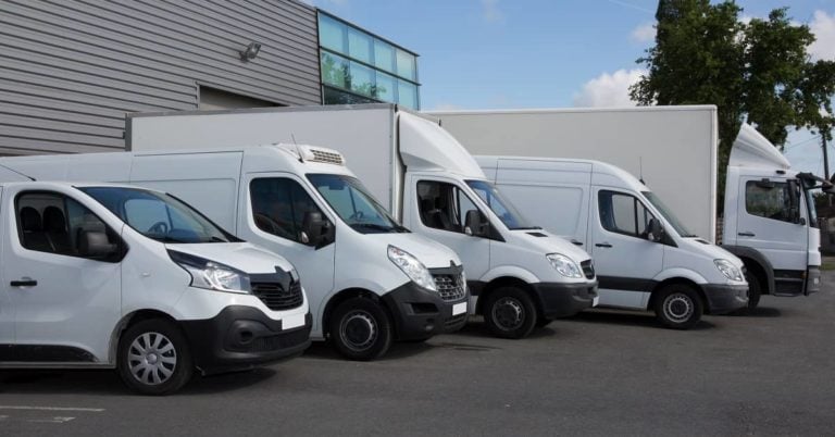 Five White Commercial vans in parking lot