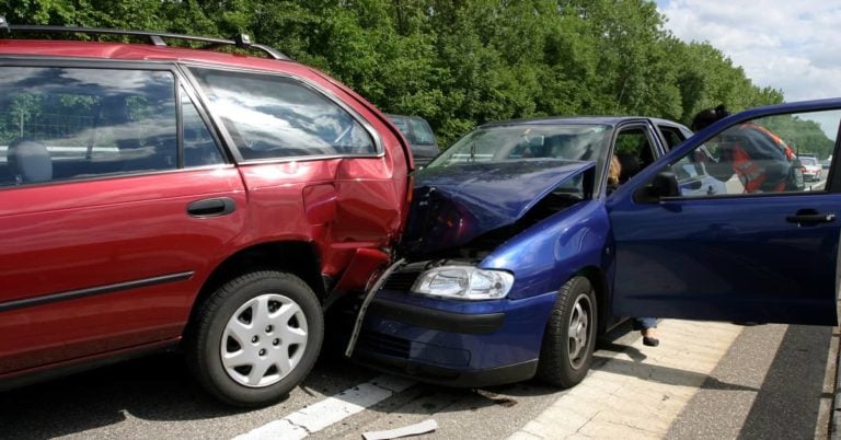 Blue car rear ended red car on highway in car accident