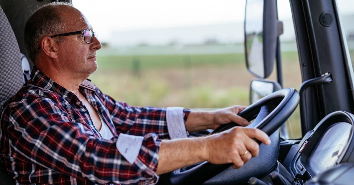 close up of man with plaid shirt driving truck on highway