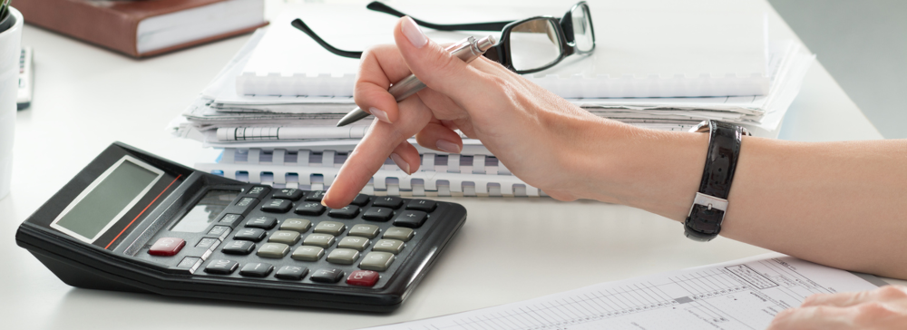 Vignette of a person using a calculator on top of financial documents