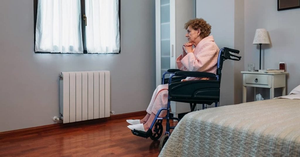 elderly women in wheelchair in nursing home room alone