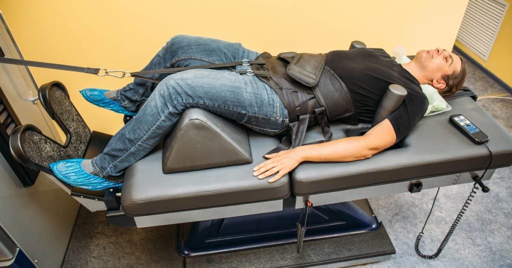 Man on spinal cord adjustment table