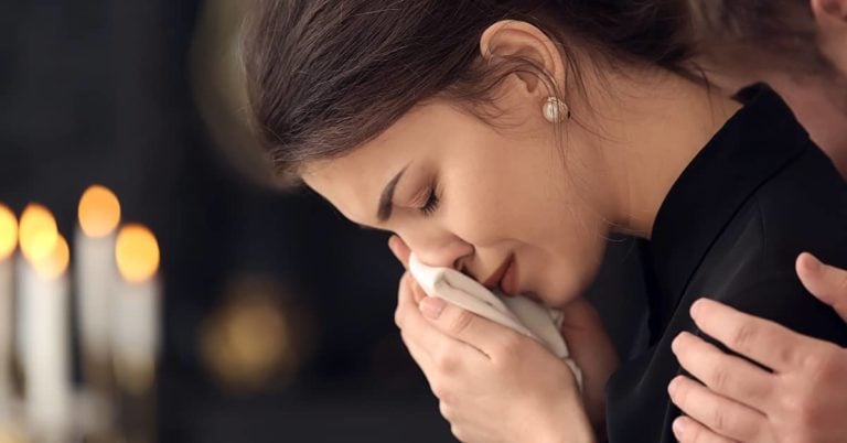 Women crying at funeral