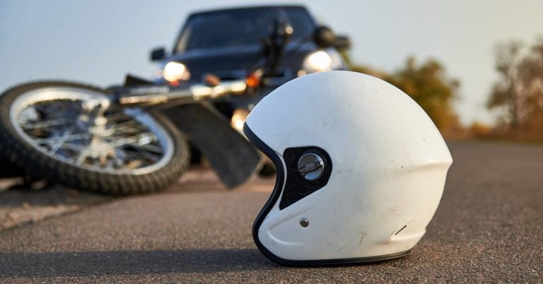 Close up view helmet with a bike and car in the back ground