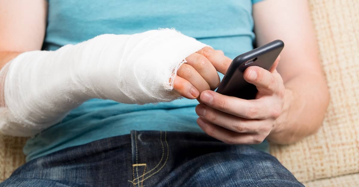 Man with broken hand going through cellphone