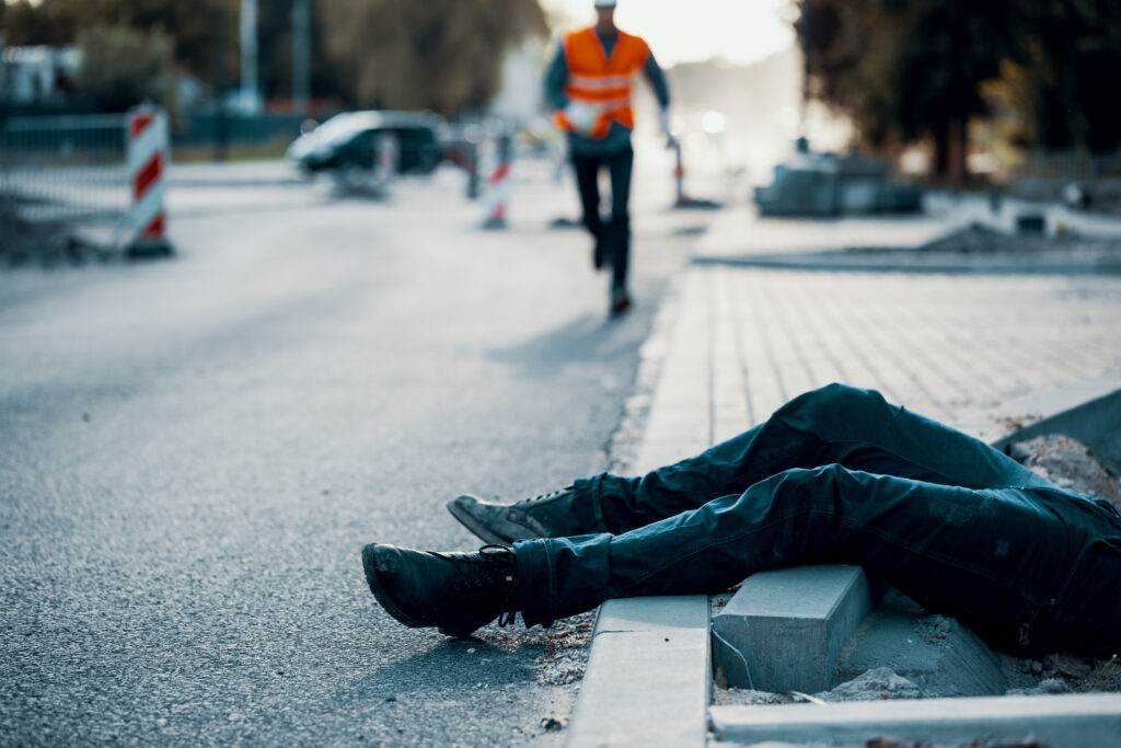 A person laying on the sidewalk after a slip and fall accident