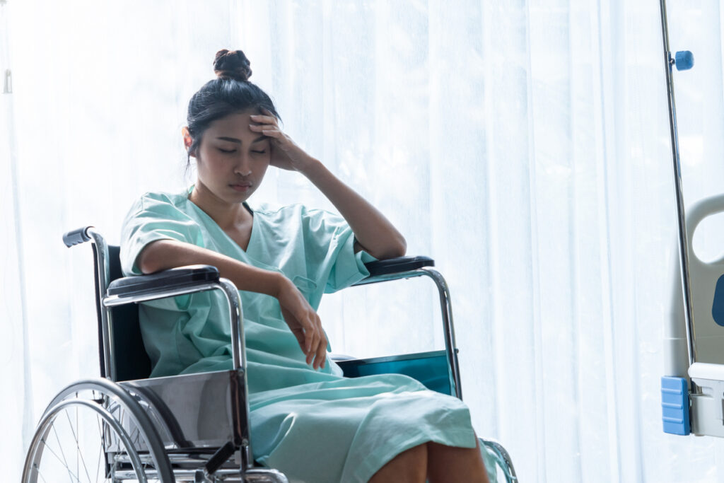 Distraught looking female patient sitting in wheelchair in a hospital room