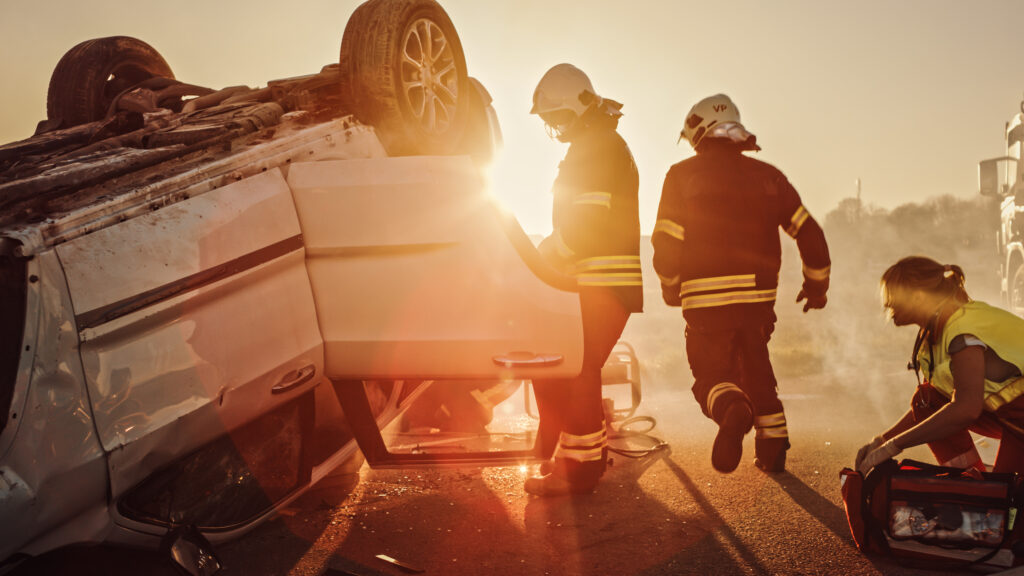Paramedics and firefighters responding to an overturned vehicle after a car accident