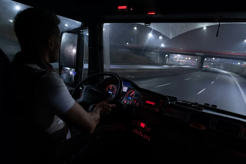 Image from the cab of a semi truck driving down the highway at night - Kogan & Disalvo