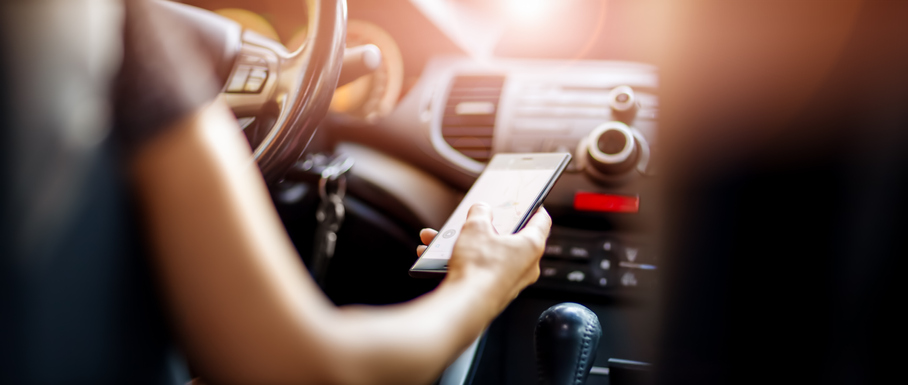 A person driving a car while looking at their phone