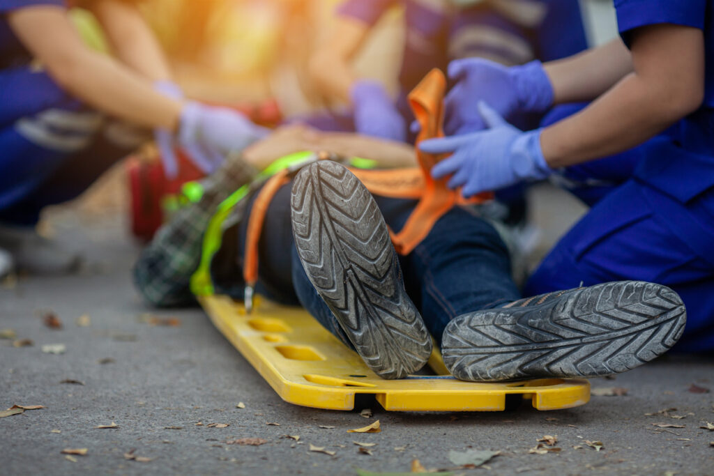 A team of paramedics strapping an injured construction worker to a stretcher