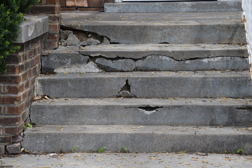 Cracked a broken cement stairway outside an apartment building