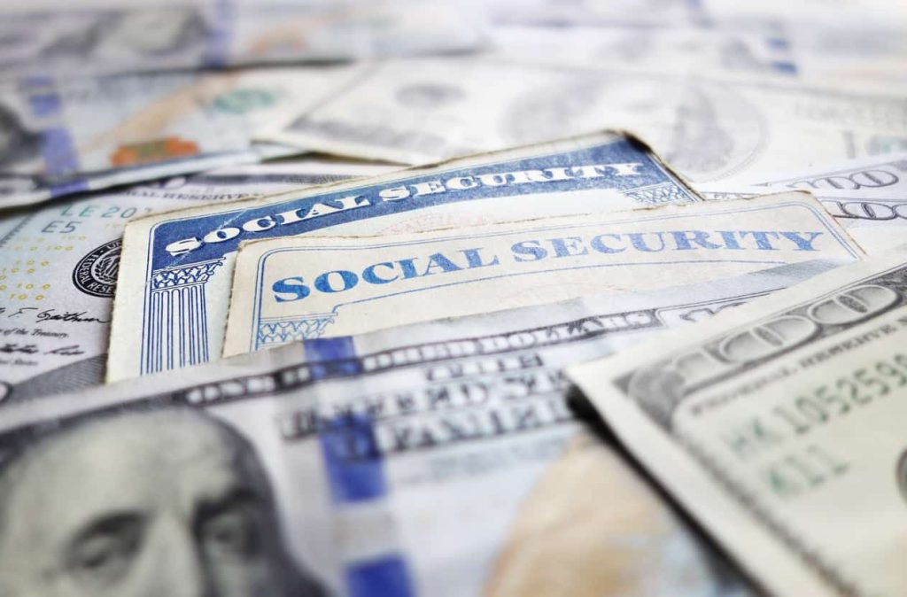 Social security cards and money laid in a pile 