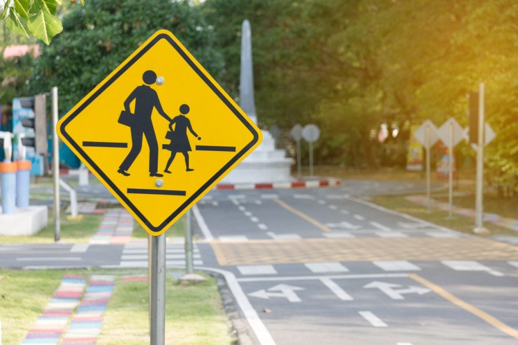 Pedestrian crossing sign alongside a city street