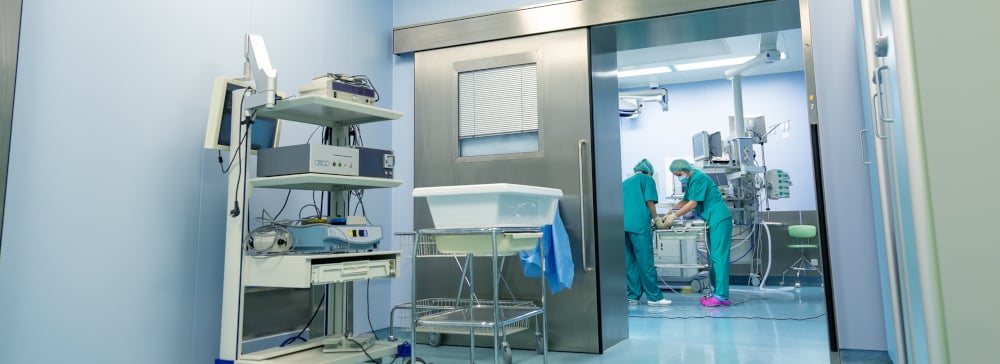 Open door to an operating room in a hospital where surgeons are working