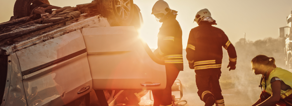 A vignette of firefighters rescuing a person from an overturned car