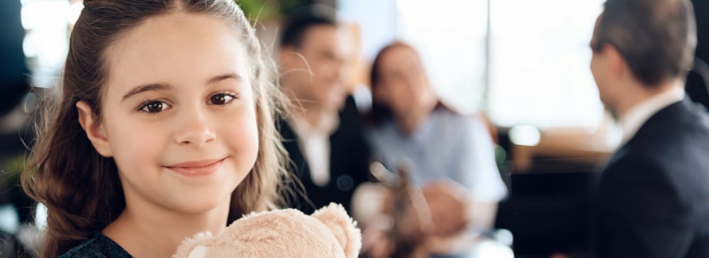 Little girl with parents talking with a layer in the background