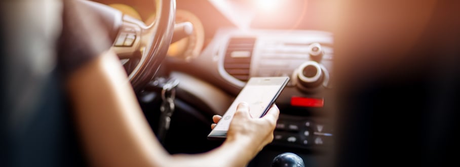 Vignette of a woman using a cellphone while driving