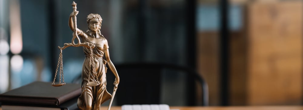 Statue of lady justice on desk of a judge or lawyer.