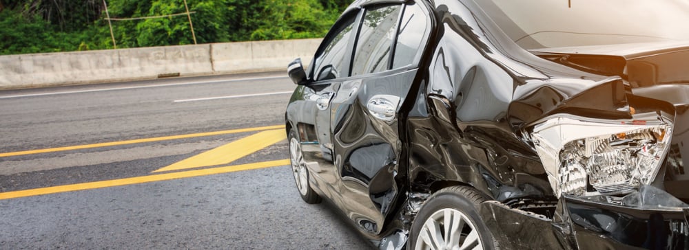 A black car with extensive damage from a side impact accident