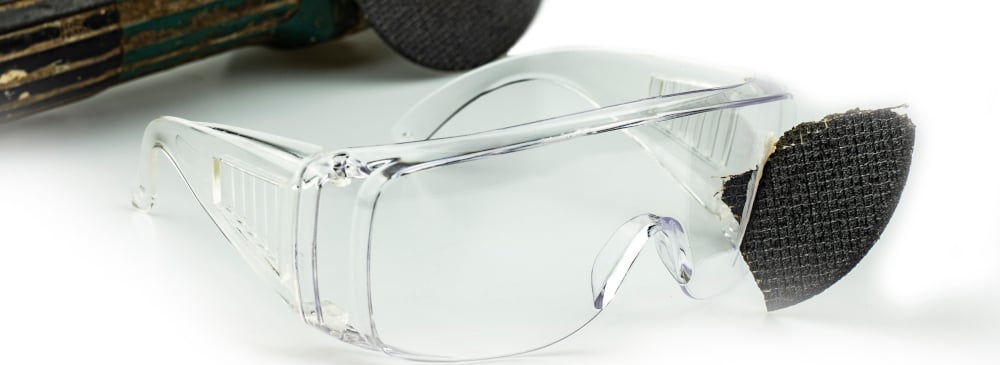Safety goggles with a shard of metal embedded in one of the lenses