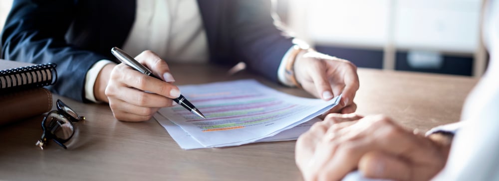 An attorney explaining a highlighted and marked up legal document to a client