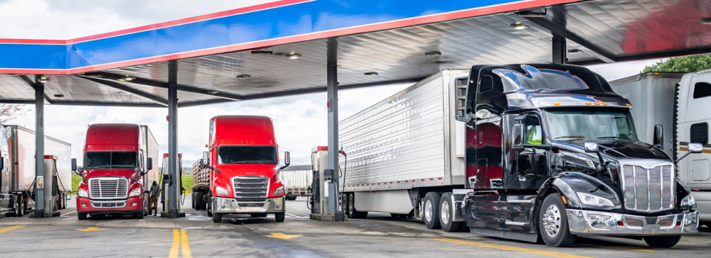 Four semi trucks parked at a truck stop gas station