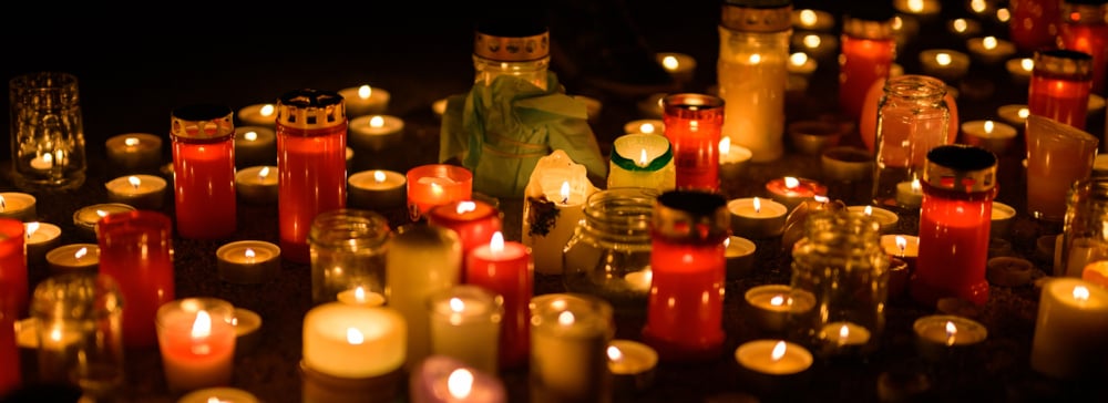 Many memorial candles burning on the ground in the night