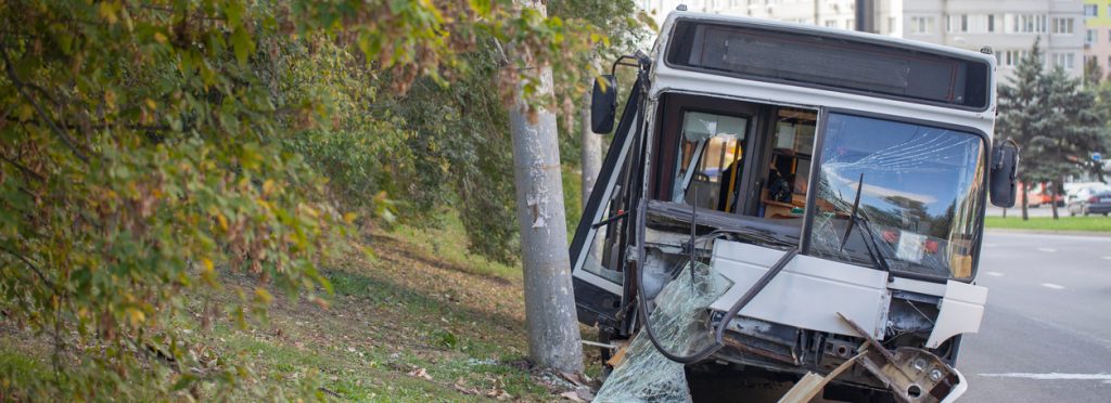 The front of a wrecked bus with a broken windshield