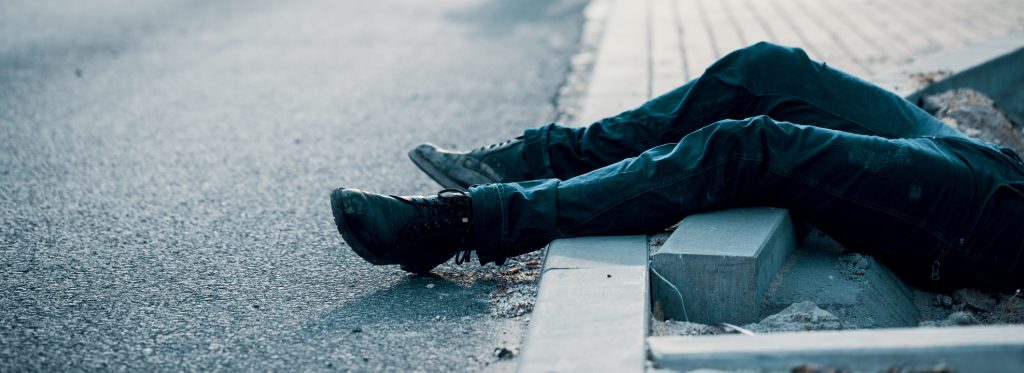 Person laying in the street partially out of frame after a slip and fall accident