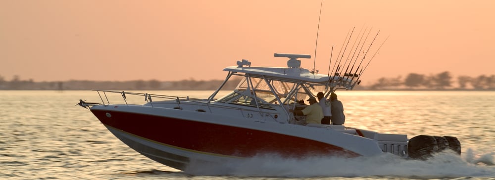 Powerboat heading out to sea at sunset