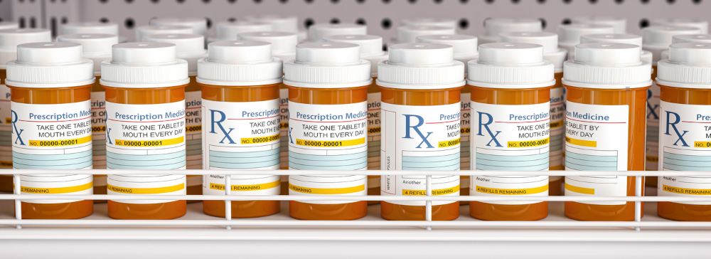 Row of prescription pill bottles on a pharmacy shelf