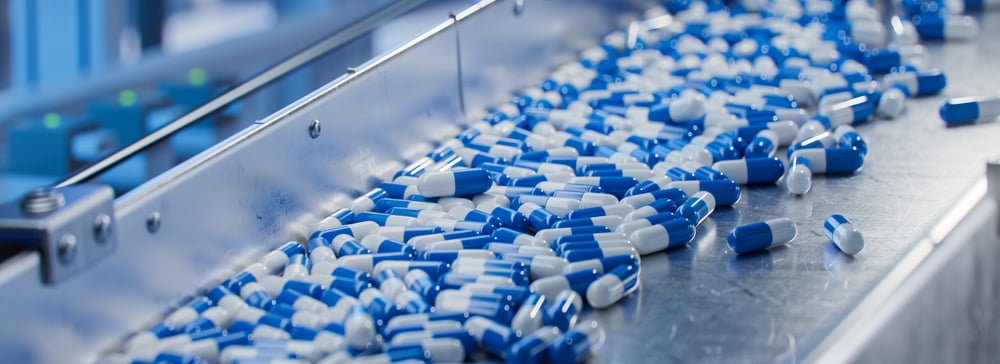 Blue capsule pills on a conveyer in a pharmaceutical factory