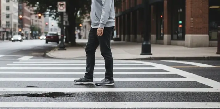 A man walks across a crosswalk on a city street