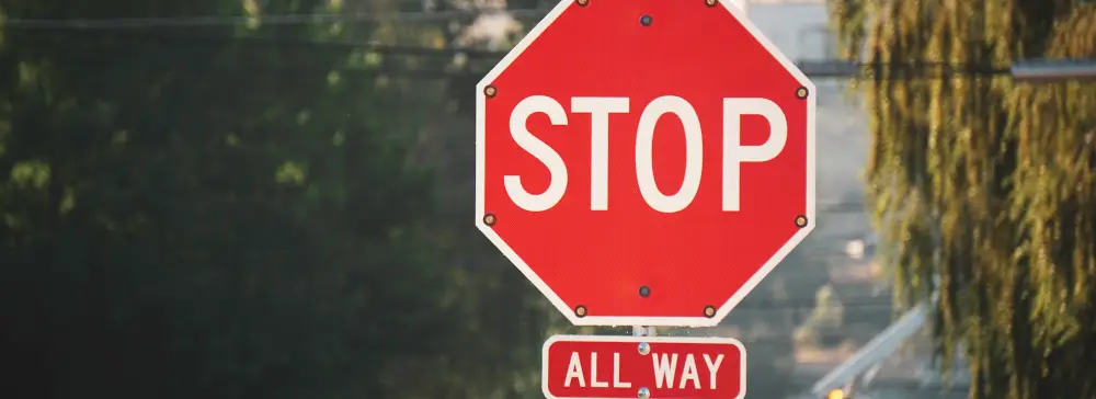 A red four-way stop sign in the city.