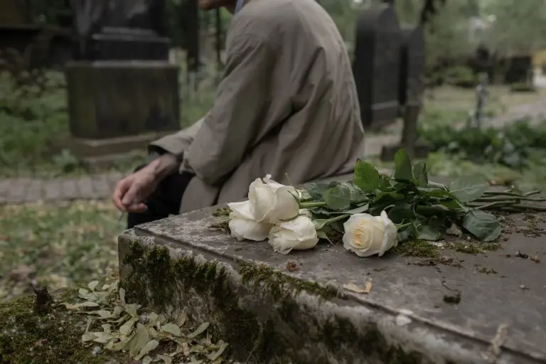 White roses placed on a grave representing the loss of a loved one in a wrongful death case